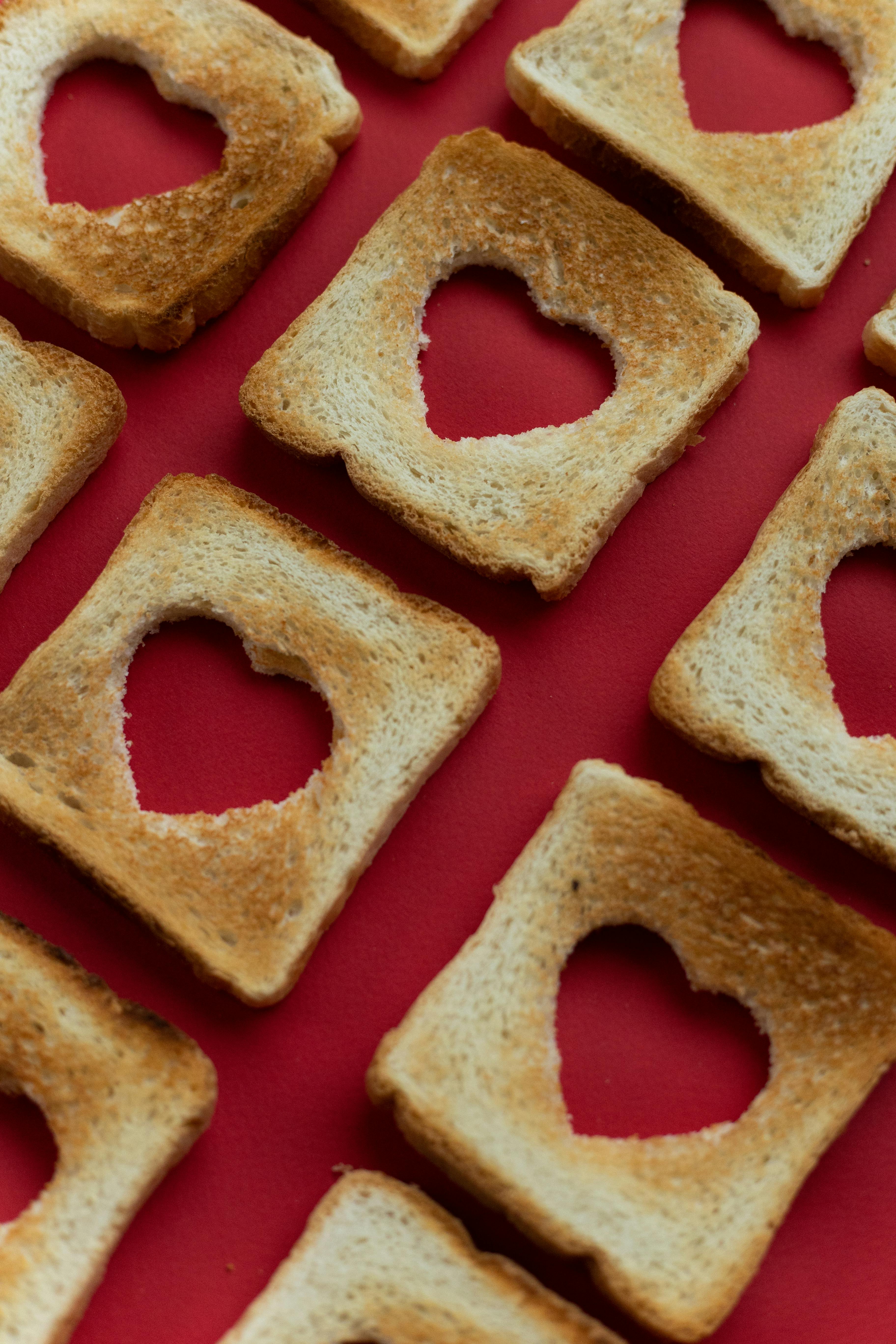 Heart Cutout Toasted Bread on Red Background