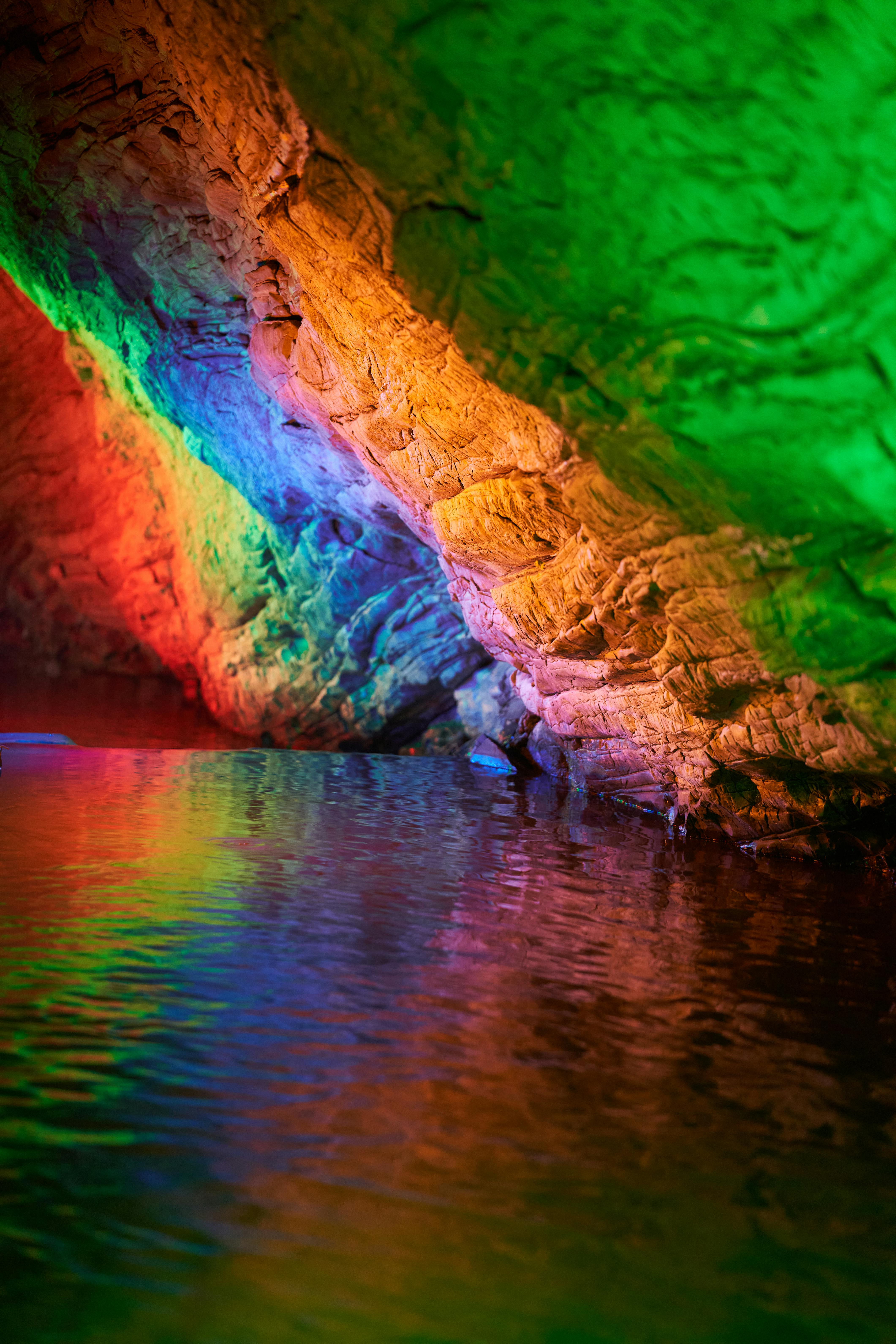 Colorfully Lit Cave with Calm Water