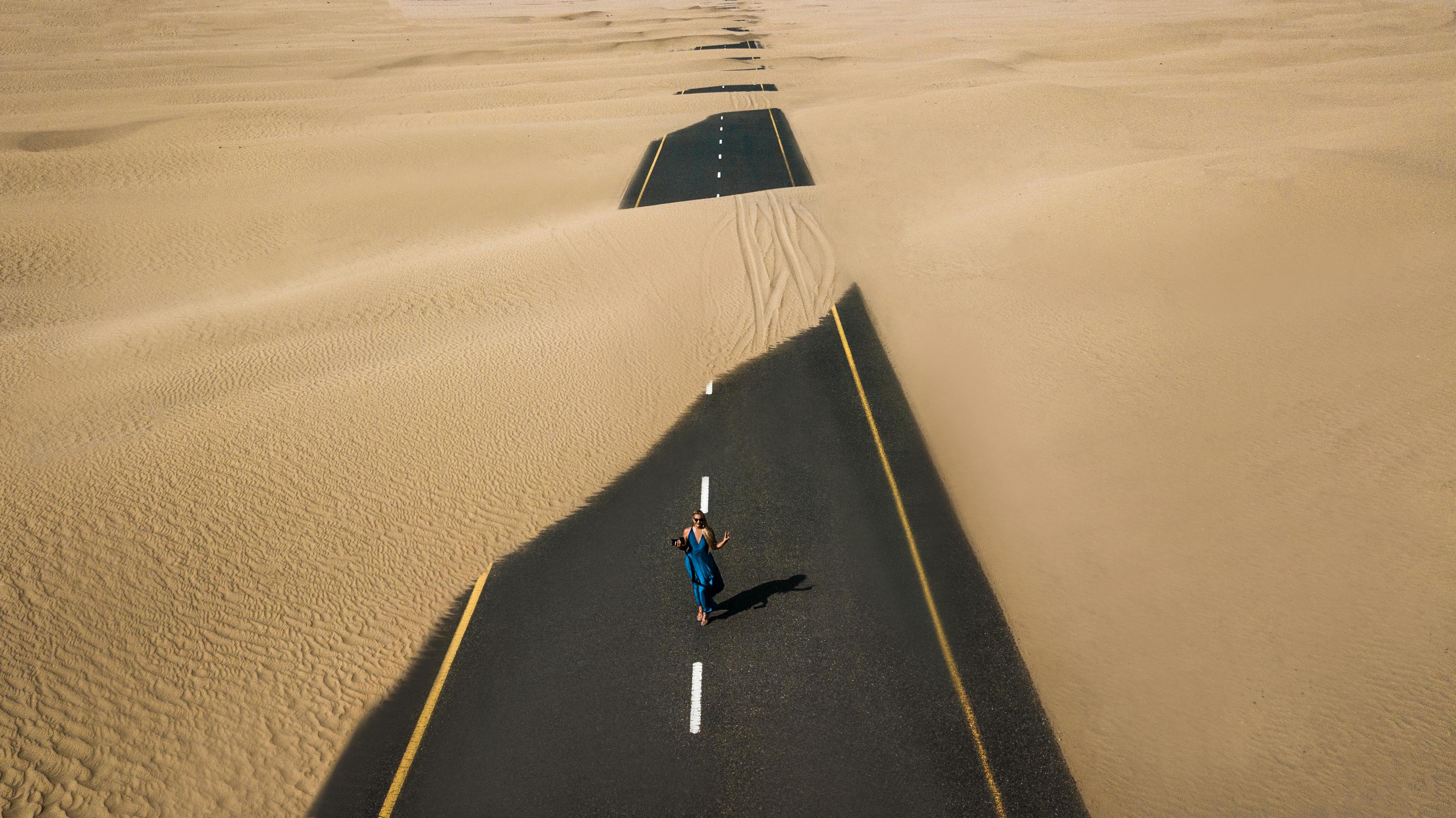 Woman on Partially Buried Desert Road — Beauty