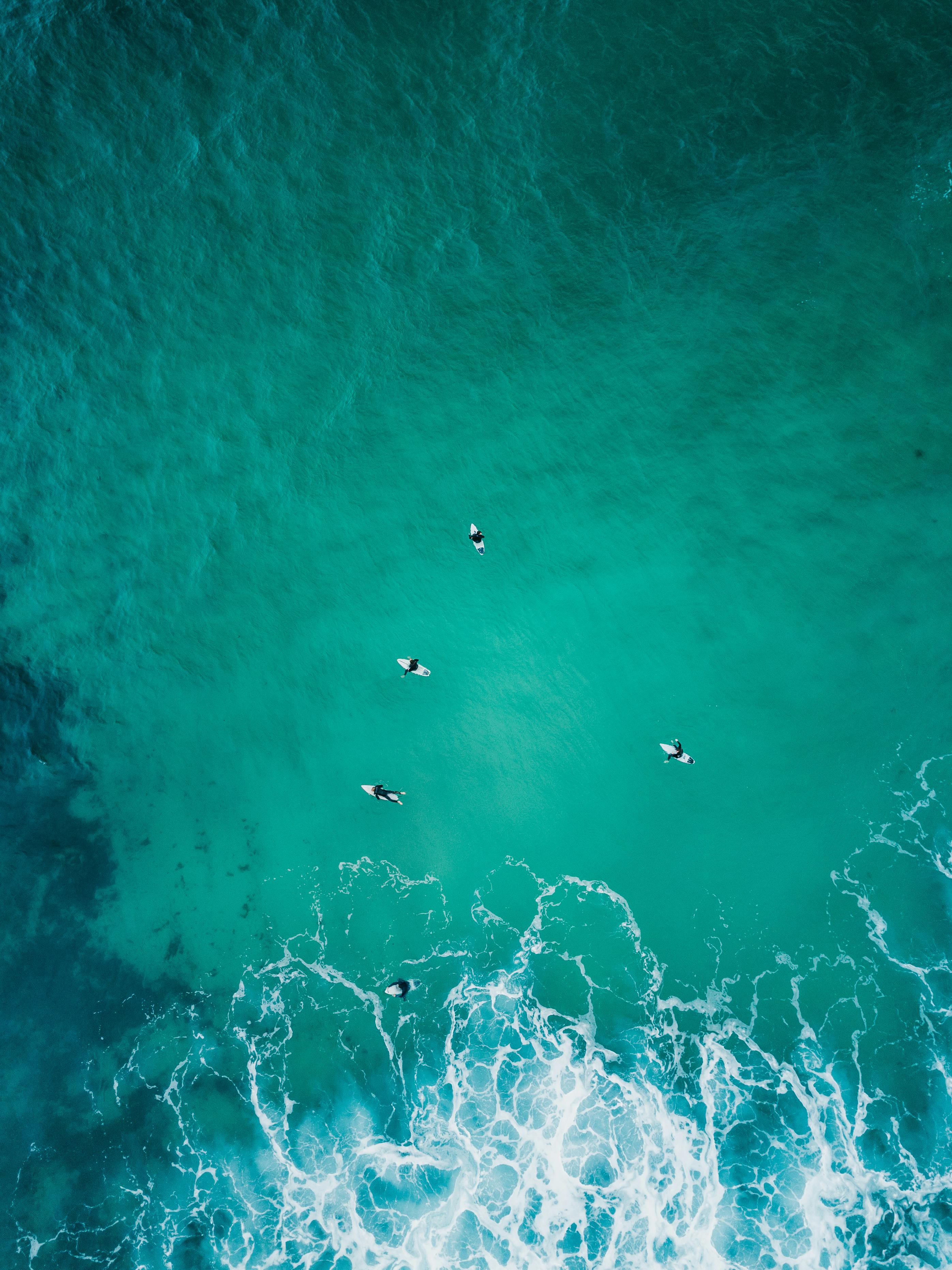 Aerial View of Surfers in Turquoise Ocean