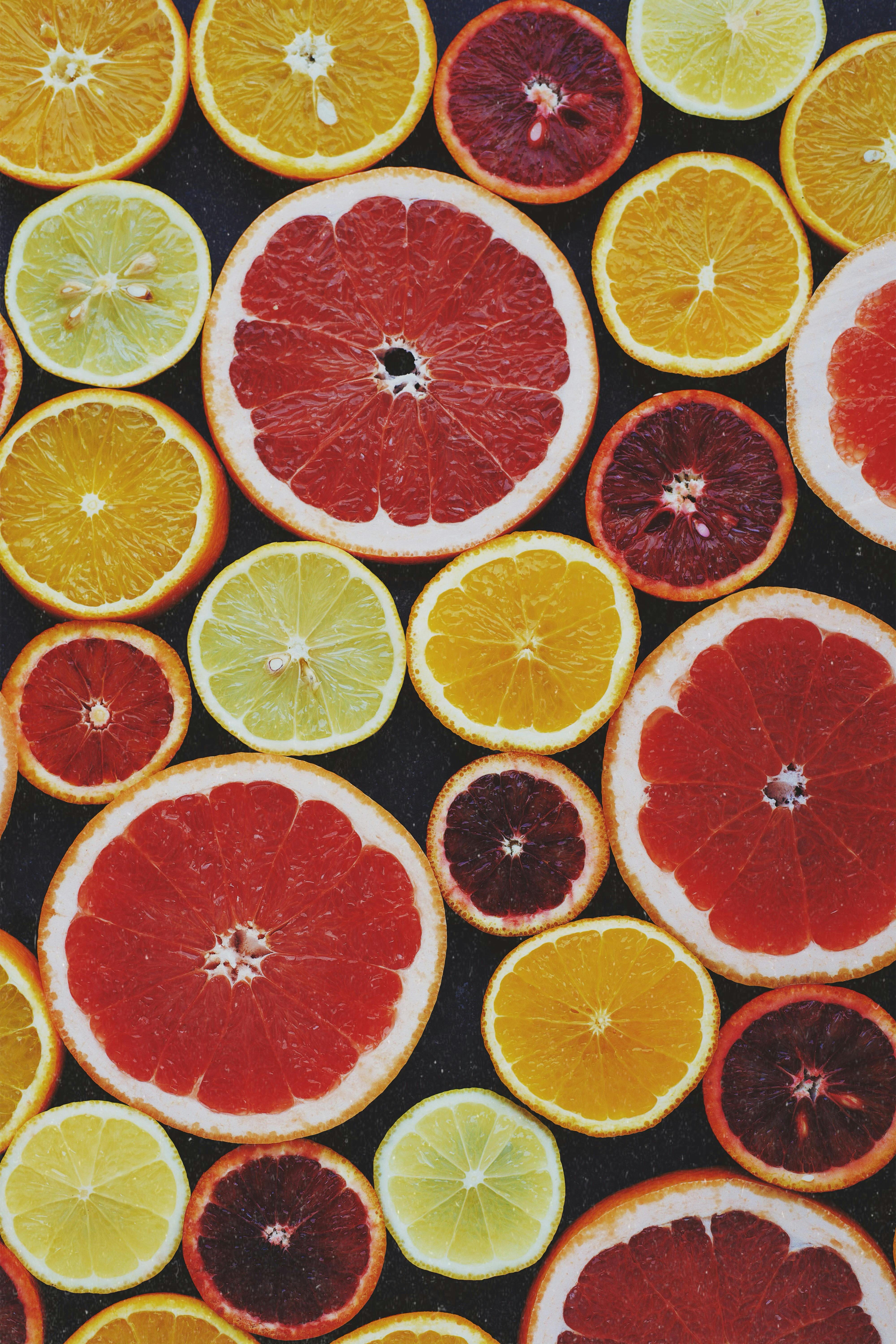 Assorted Sliced Citrus Fruits on Dark Background