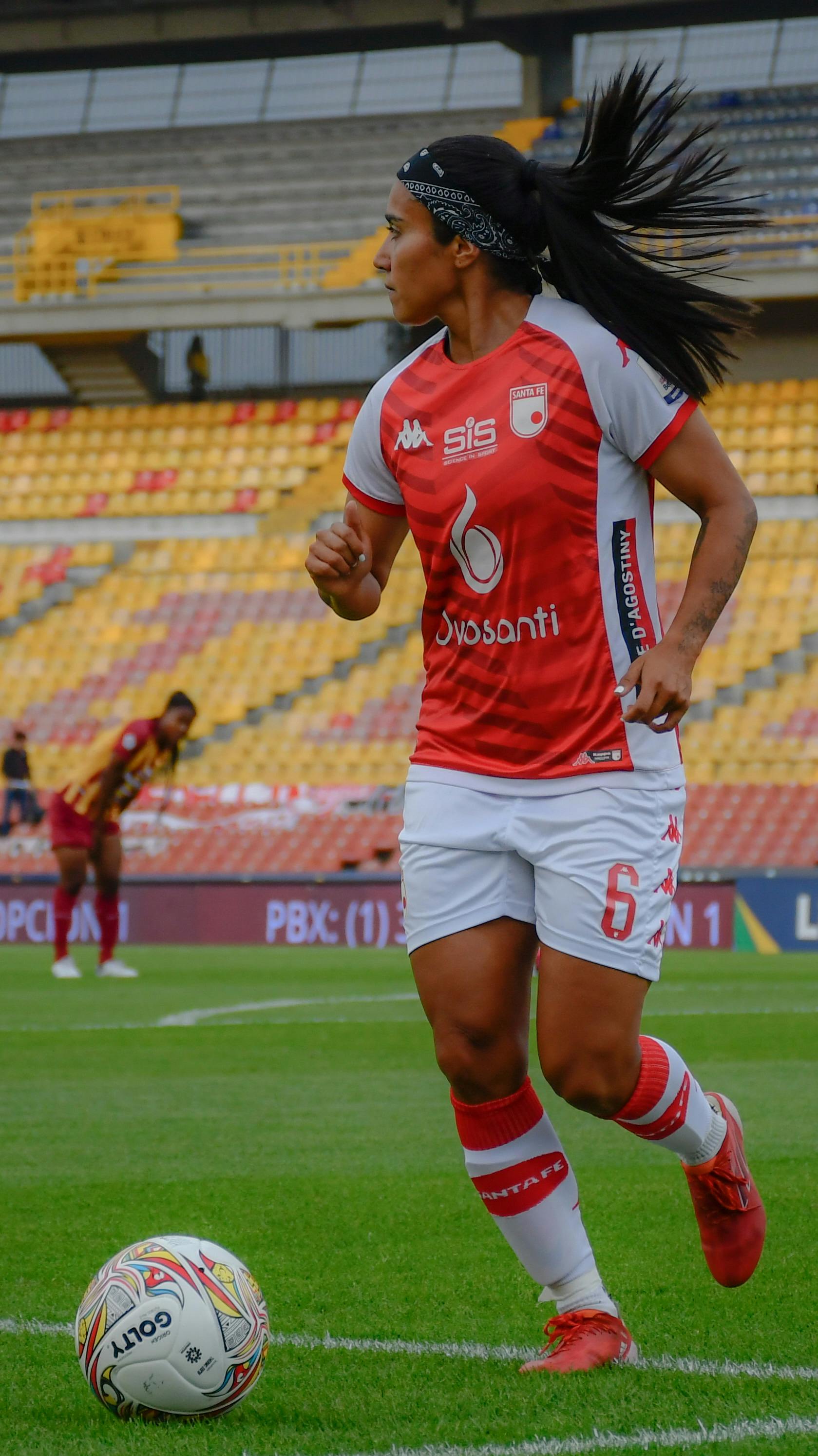 Female Soccer Player Running on Pitch