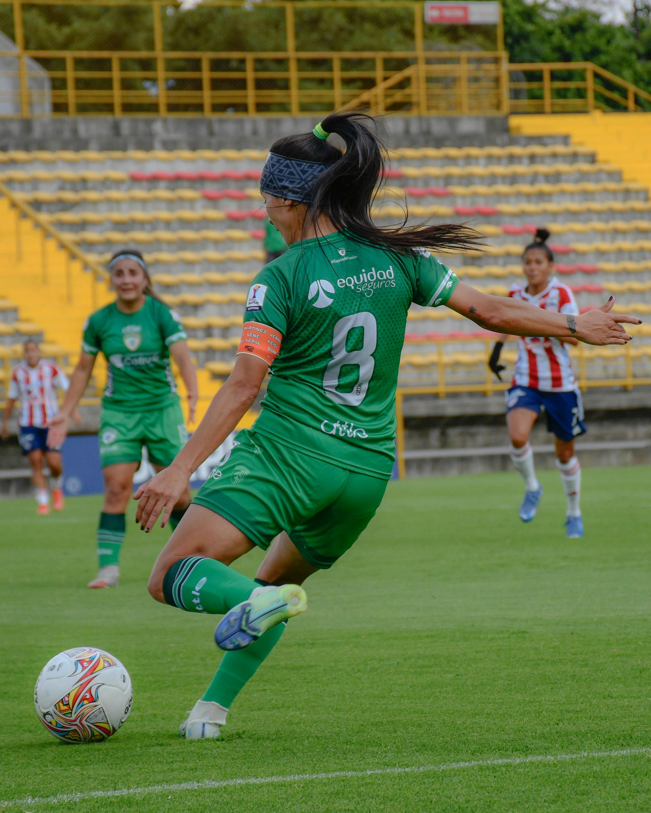 Female Soccer Player Kicking Ball
