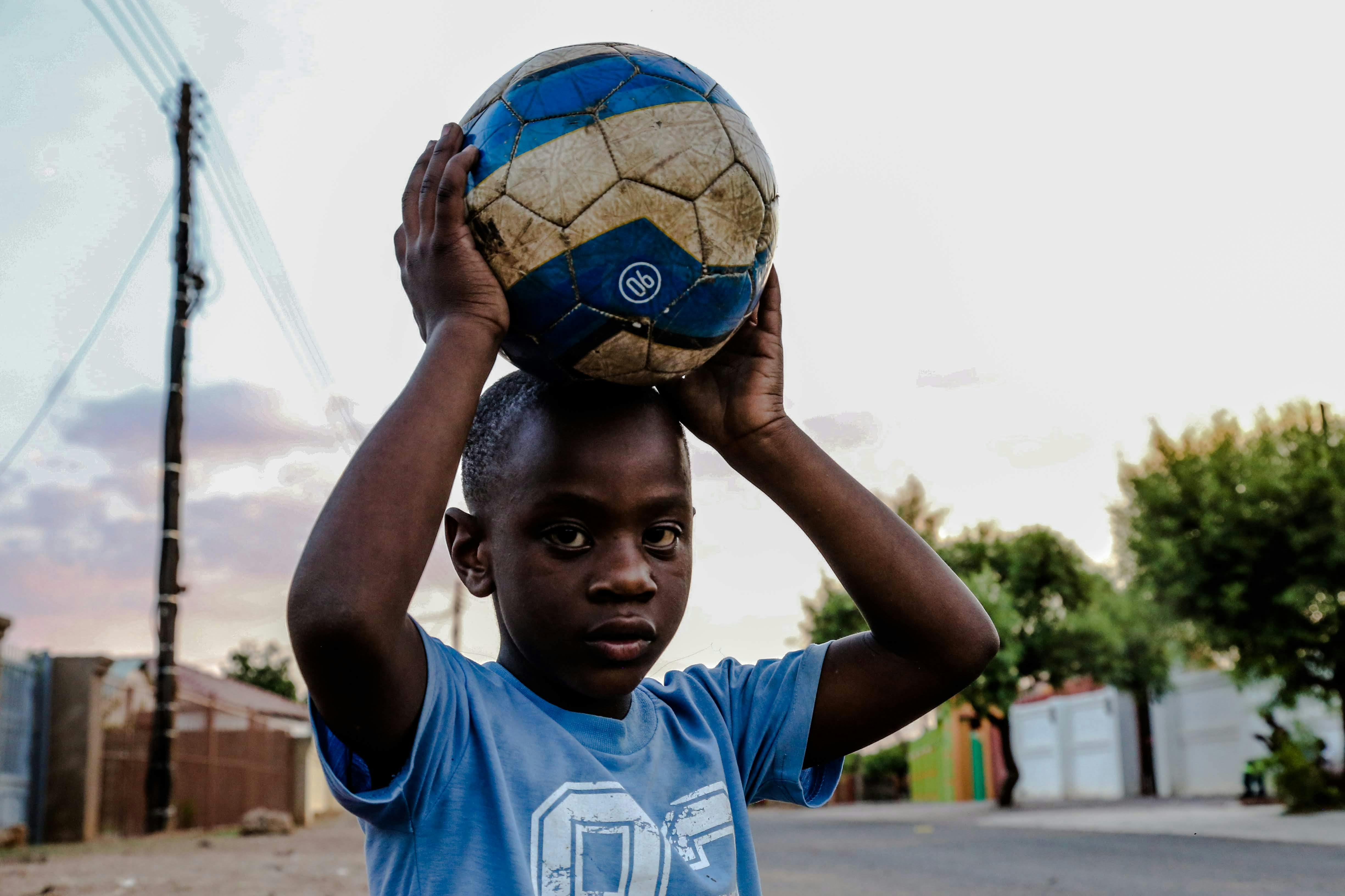 Boy Holding Soccer Ball on Head