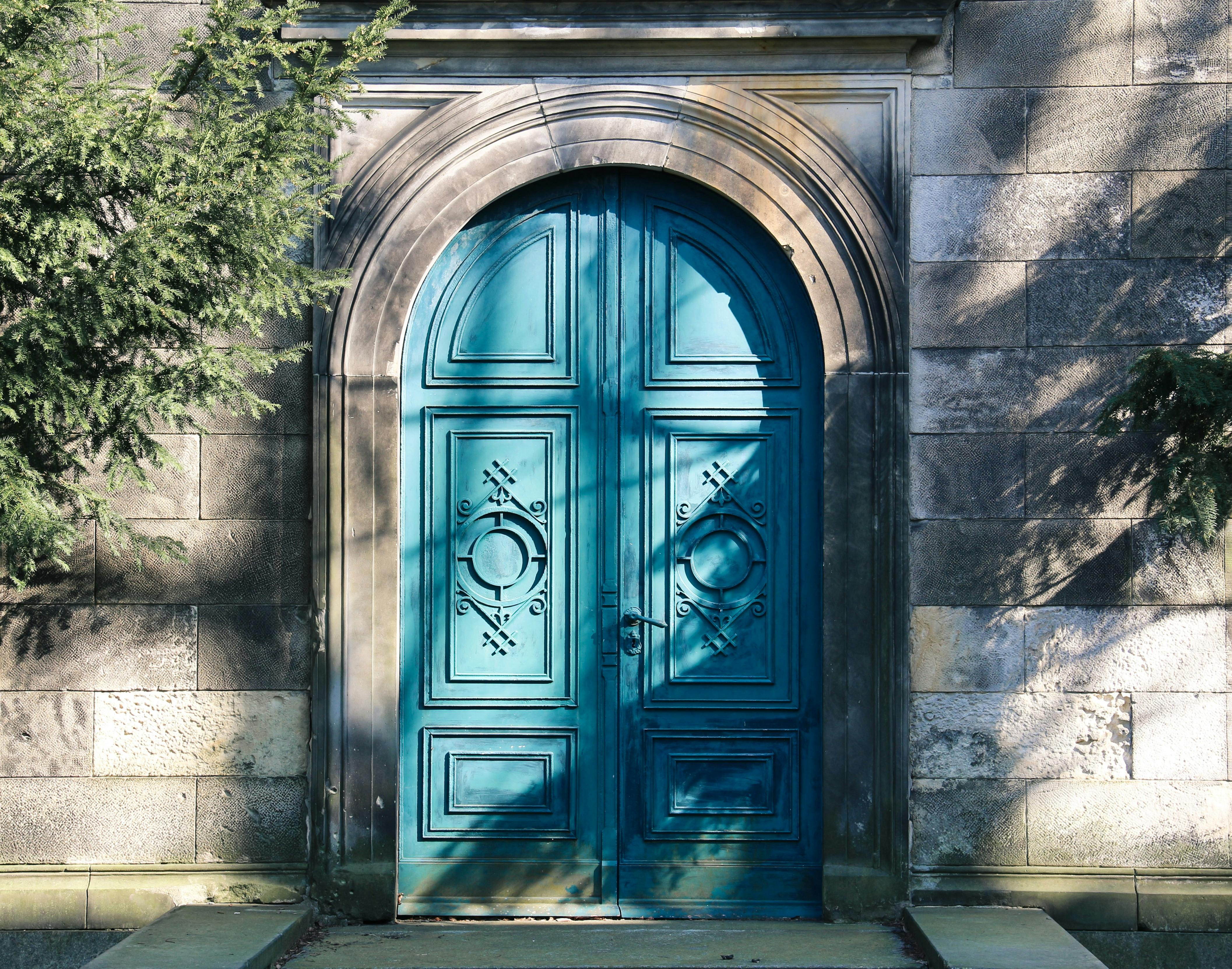 Arched Teal Double Door in Stone Wall