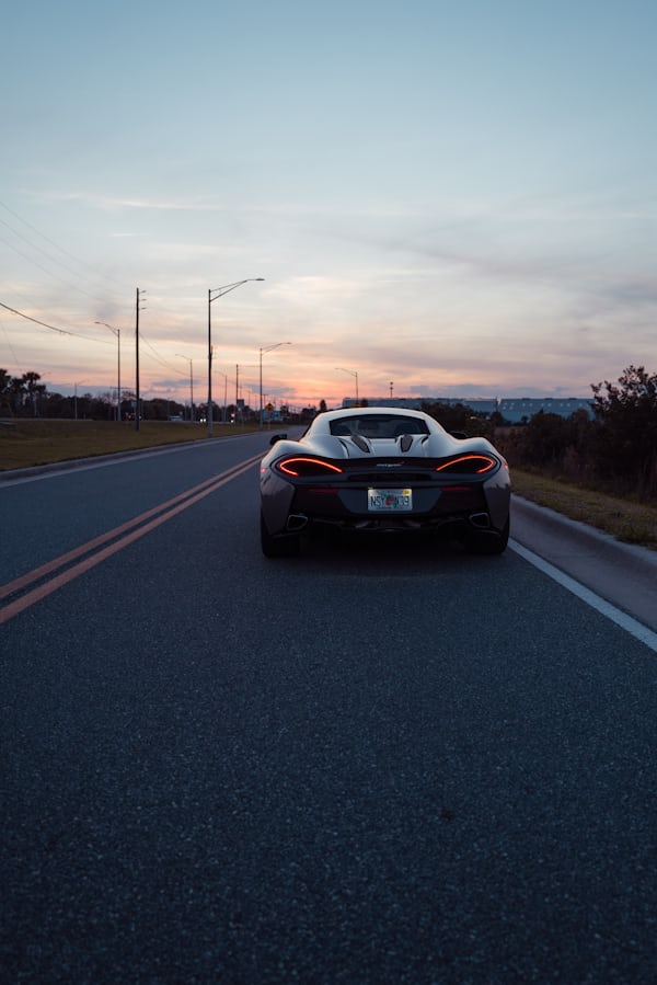 Sports Car on Road at Sunset
