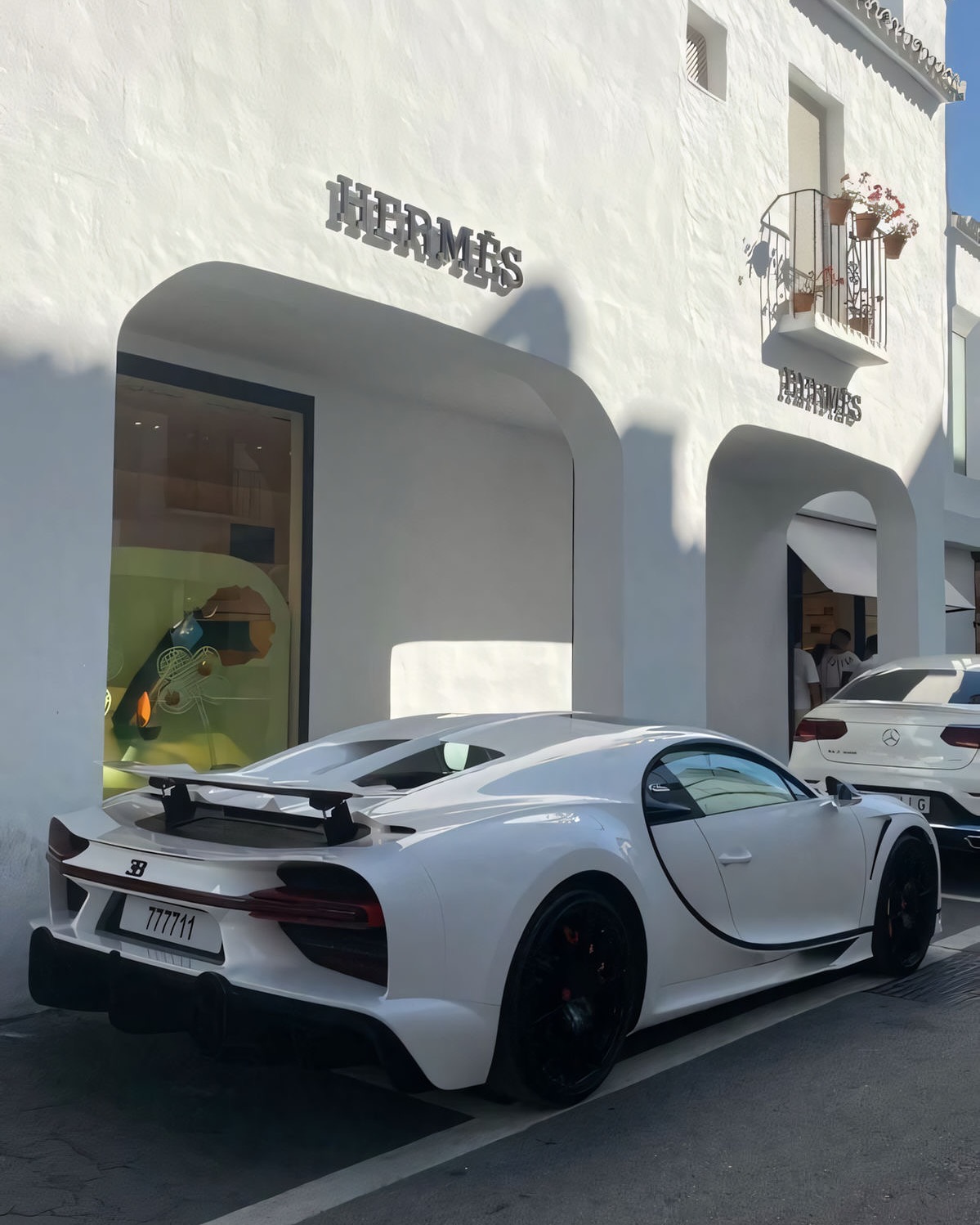 White Bugatti parked outside Hermes store
