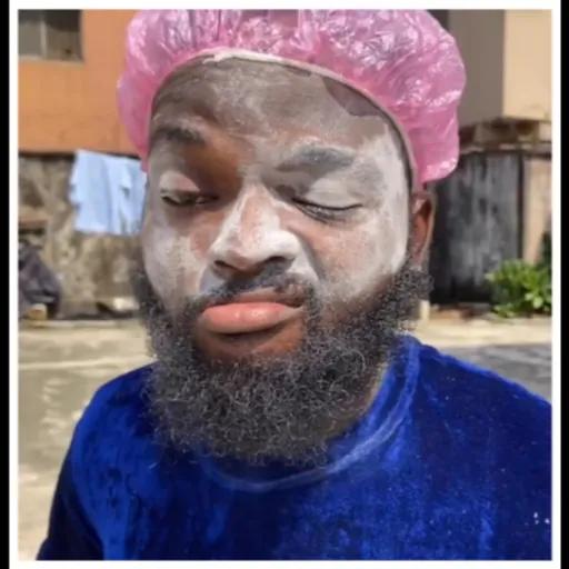 Man with facial mask and pink shower cap